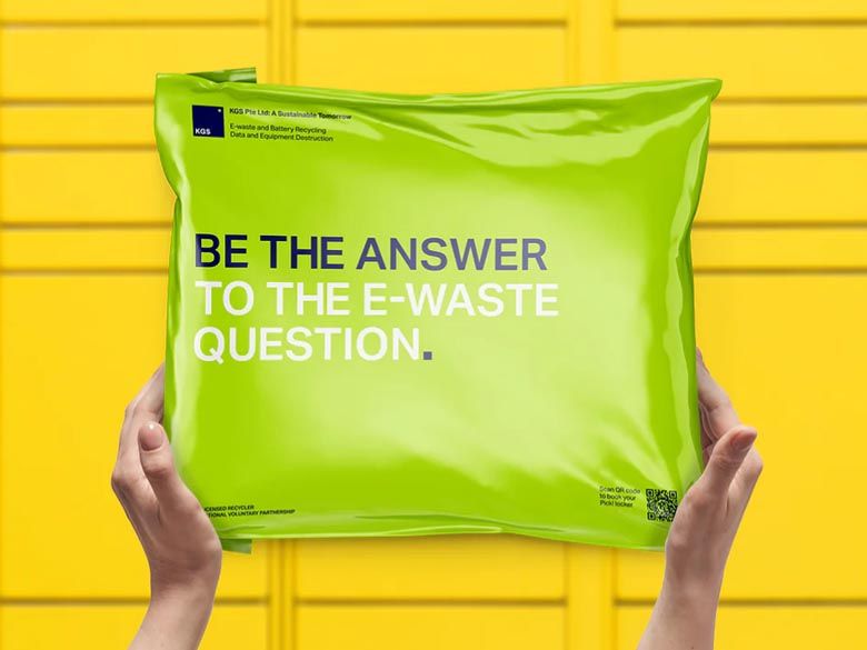 Hands hold a shiny green package reading "Be the answer to the e-waste question" against a bright yellow background. Hands hold a shiny green package reading "Be the answer to the e-waste question" against a bright yellow background.